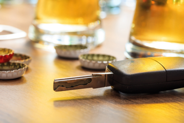 Car keys on table, alongside pints of beer