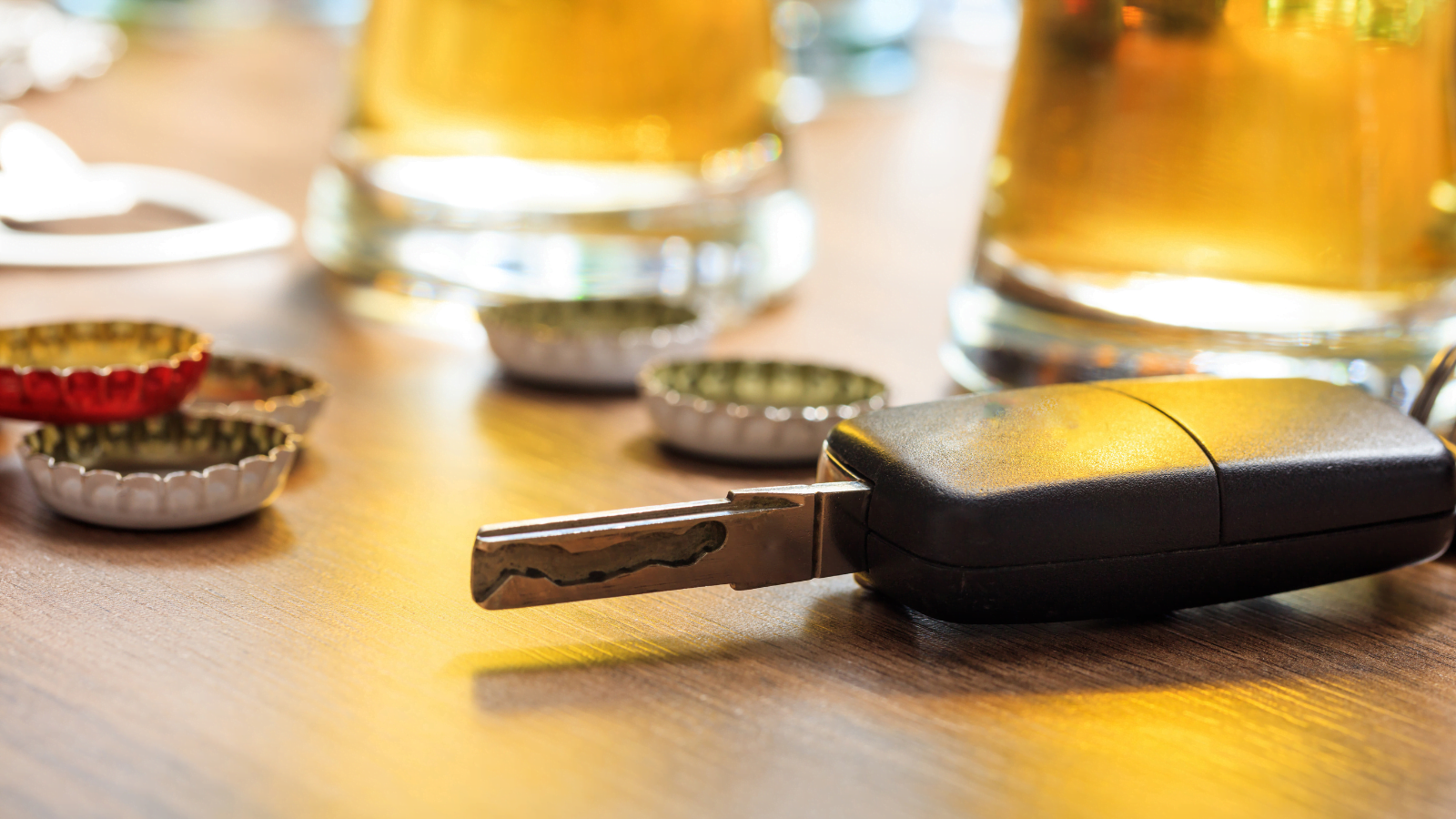 Car keys on table, alongside pints of beer