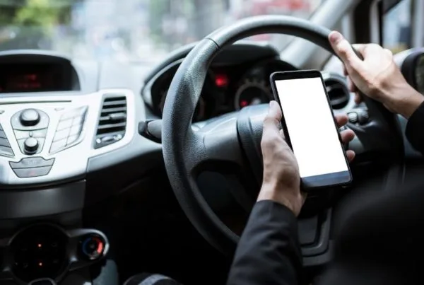 Person using mobile phone behind the wheel