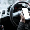 Person using mobile phone behind the wheel