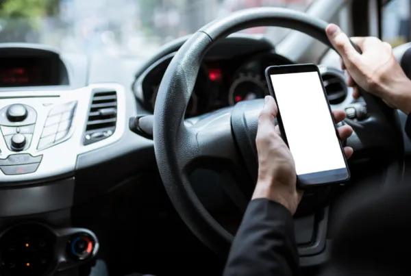 Person using mobile phone behind the wheel