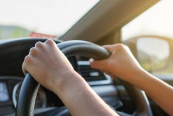 Picture of someone driving a car, taken from the interior