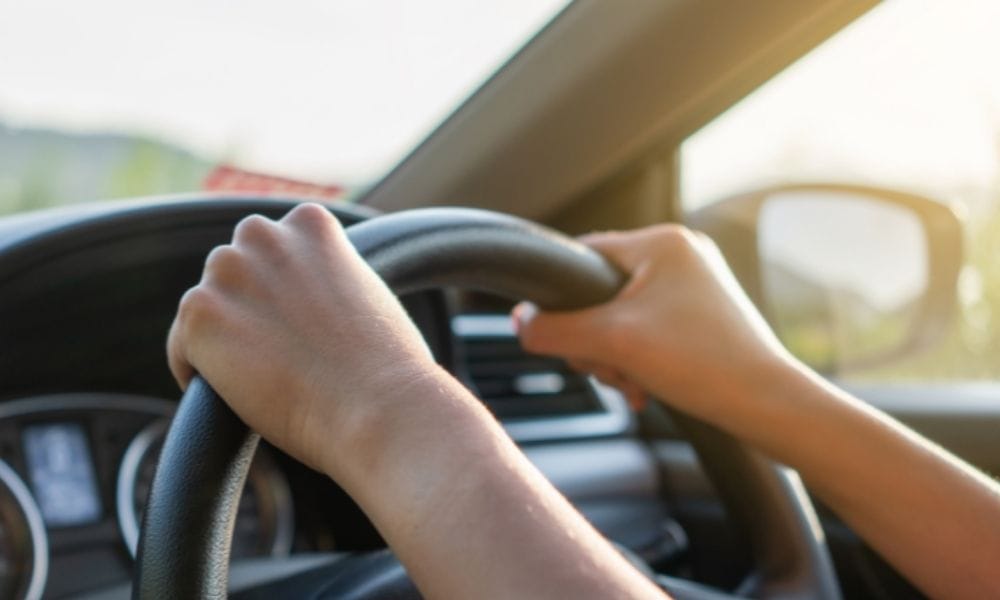 Picture of someone driving a car, taken from the interior