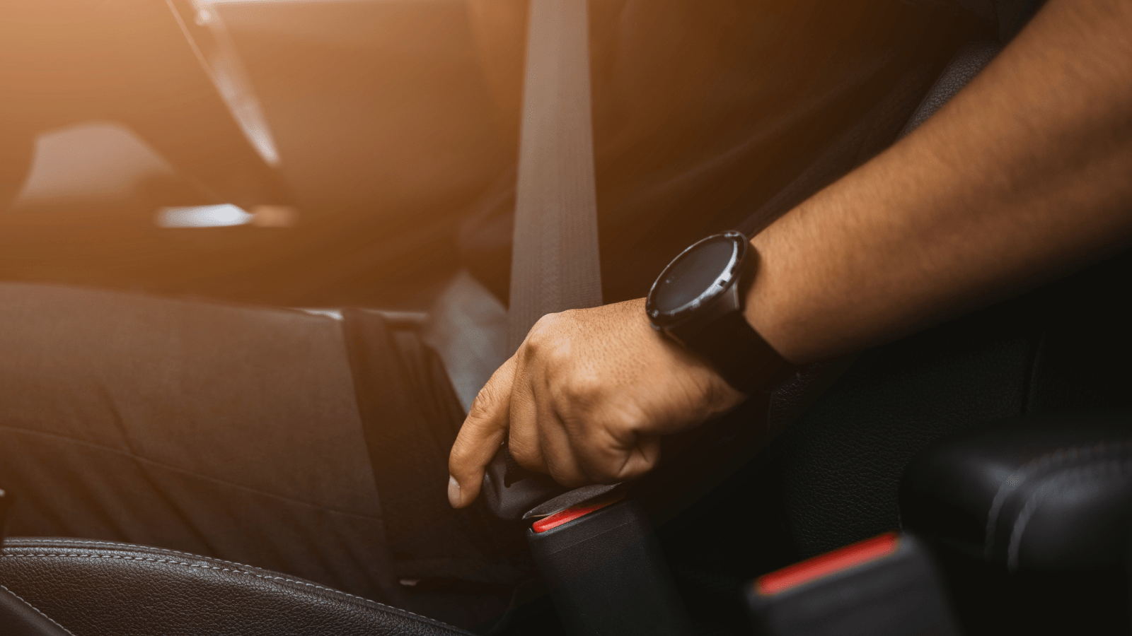 Picture of individual fastening their seatbelt in a car.