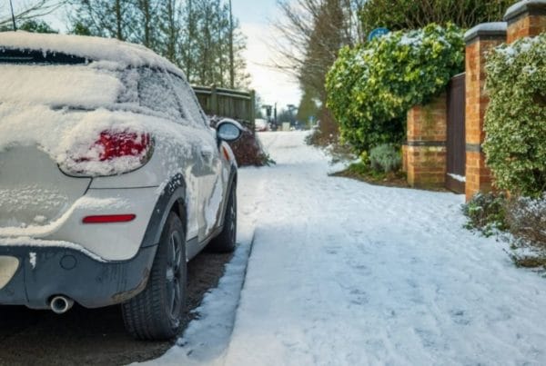 Car parked on winter snow road in town in england uk during covid lockdown