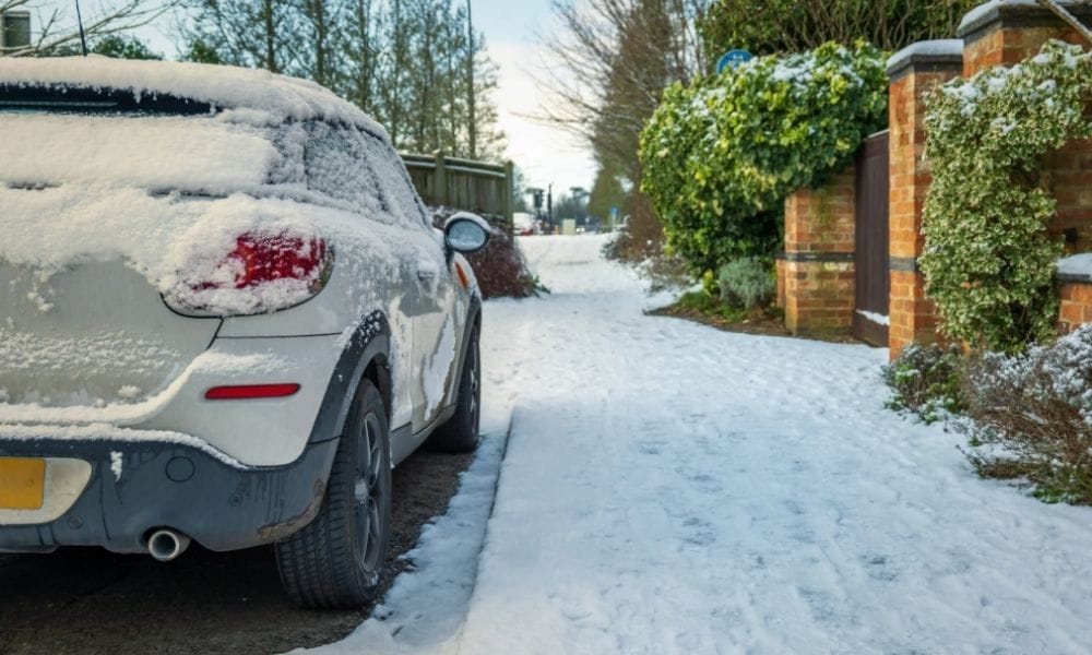 Car parked on winter snow road in town in england uk during covid lockdown